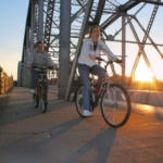 Couple Biking Across Bridge in Downtown Grand Forks All Four Seasons