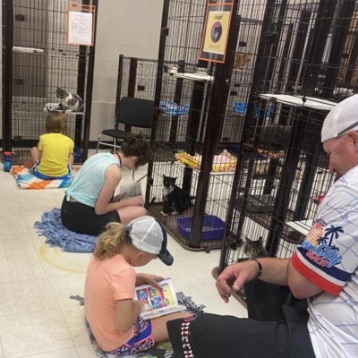 Volunteers in Grand Forks Animal Shelter Volunteers reading to cats in Grand Forks animal shelter.