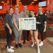 unnamed 800 1 Five people, including writer Henessy, hold a "brag board" at Orange Theory Fitness