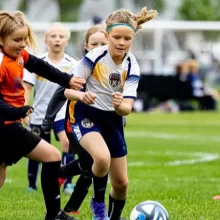 Grand-Forks-Soccer-Club Girls fighting over the soccer ball on the field in Grand Forks.
