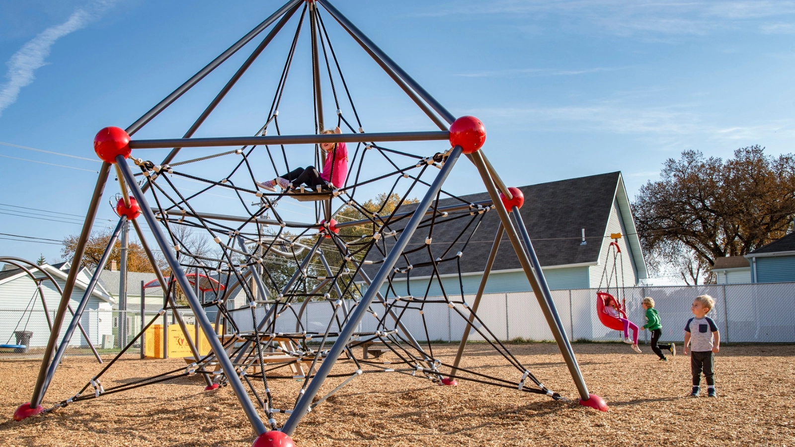 park-spider-climbing Three kids play on a spider web structure at a Grand Forks park.