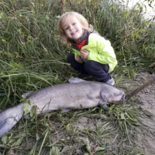 baby-avery-with-catfish-on-riverbank Avery Anderson posing with a Channel Catfish he helped catch off the riverbank near his house. Fish Species: Channel Catfish.