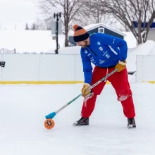 Downtown Grand Forks winter broomball Winter activities in Grand Forks are fun. This image is a man playing broomball in the winter in downtown Grand Forks.