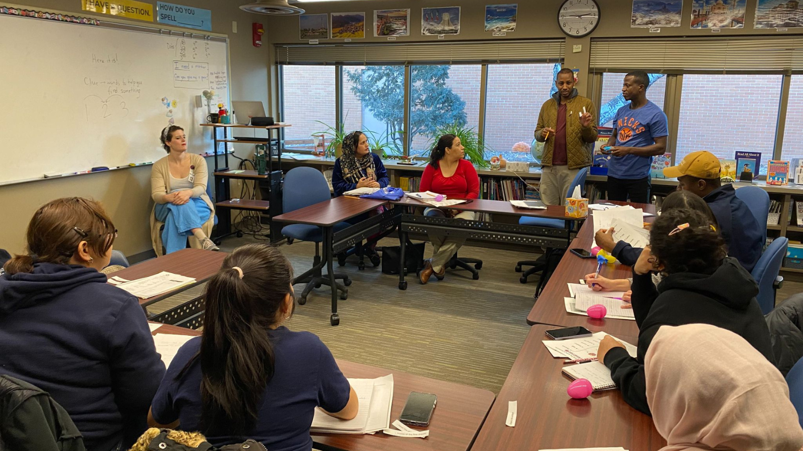 A photo from English lessons in a classroom where some of the students are standing up and talking