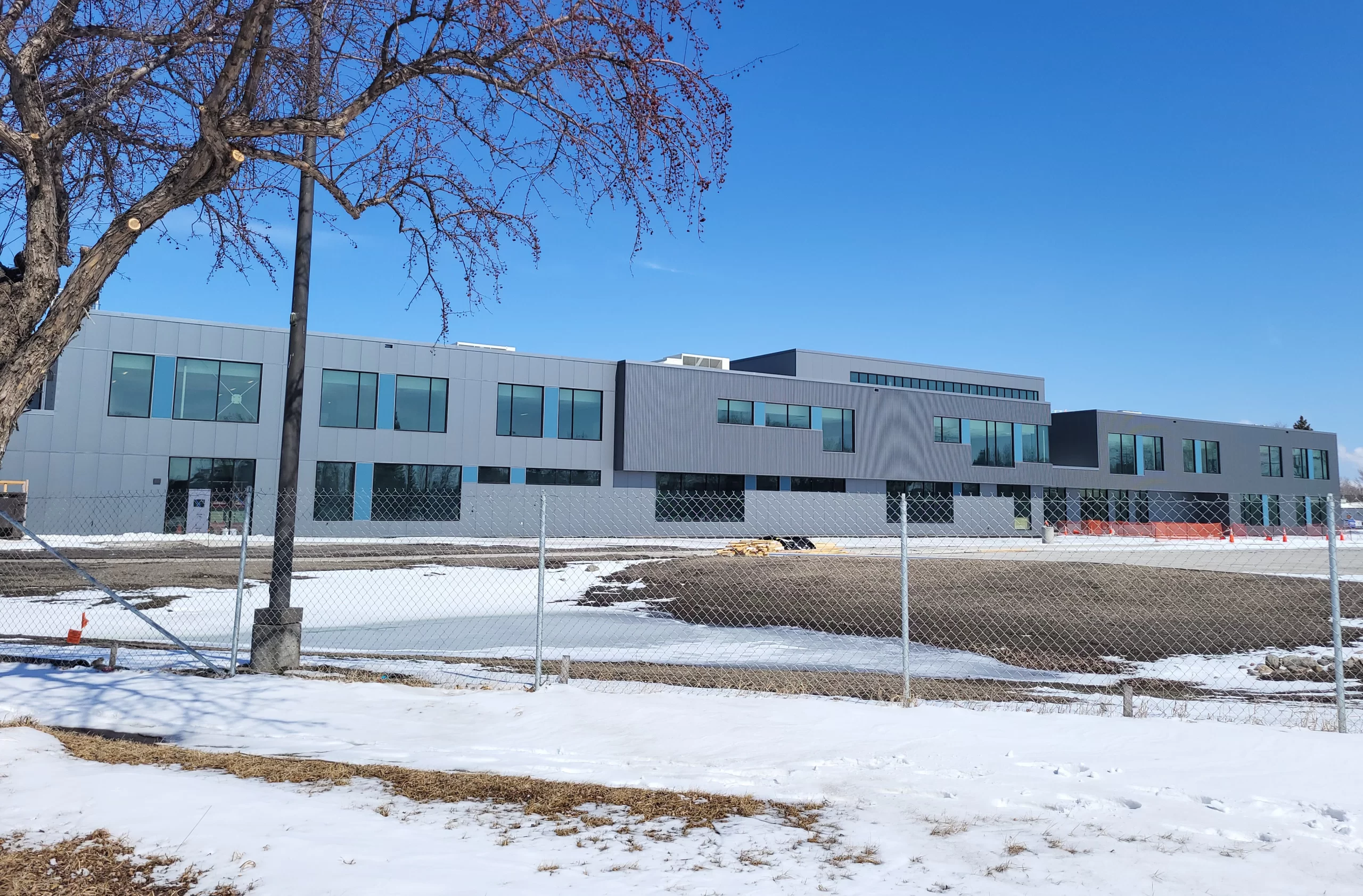 This photo shows the exterior of the current Career Impact Academy being built. It is all shades of grey and has loads of windows!
