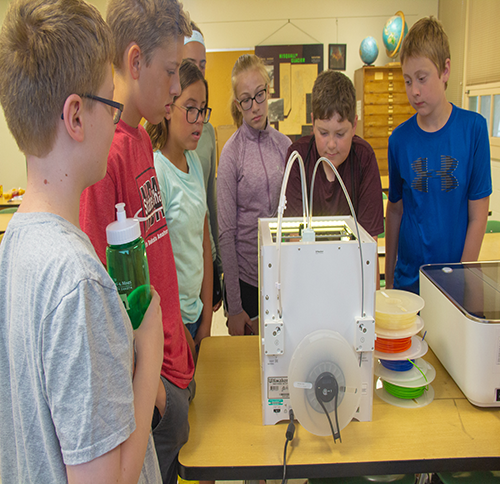 Engineering Camp Photo A group of seven kids stand around a project they've been working on at engineering camp