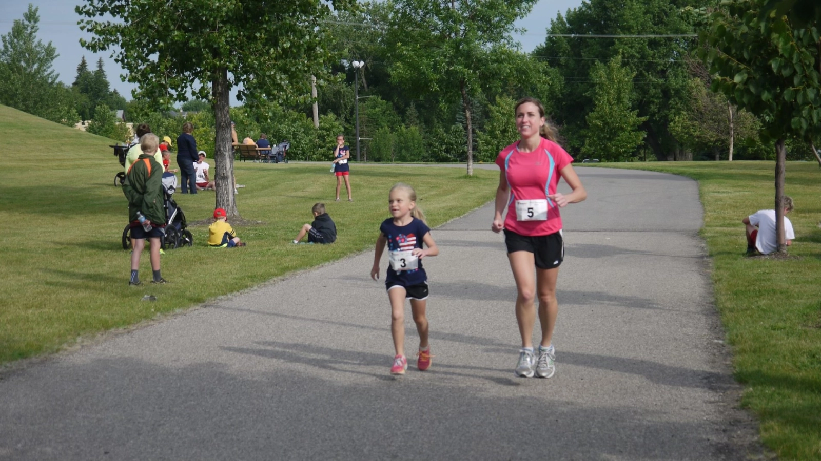 Runners photo A mother and daughter run side by side in a race through Grand Forks Greenway