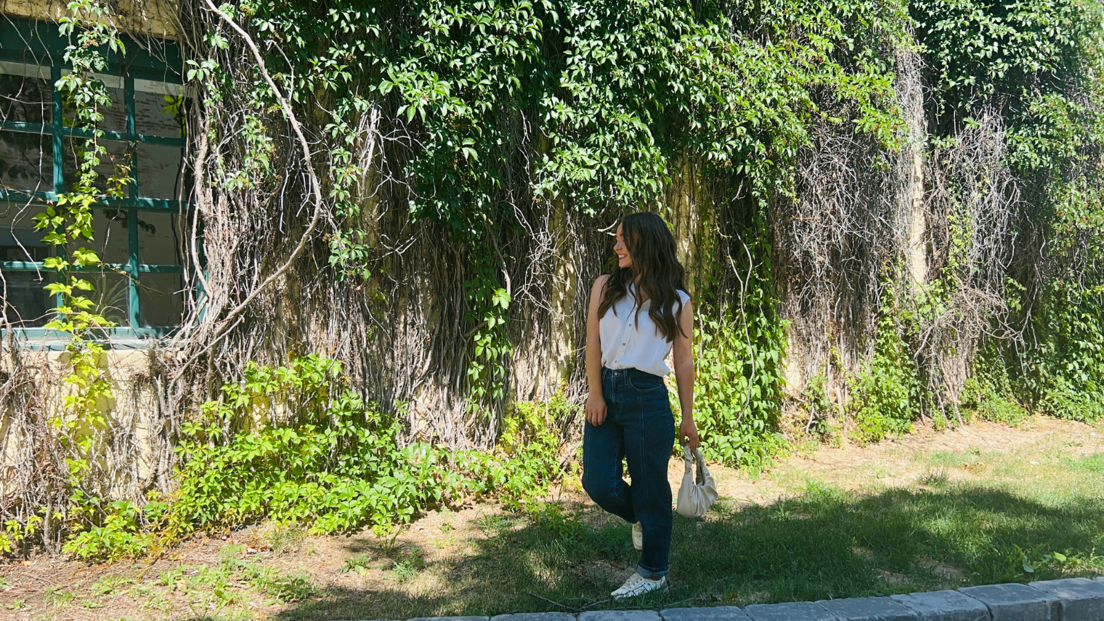 Author Natalie poses in front of the large ivy wall downtown outside Ely's Ivy