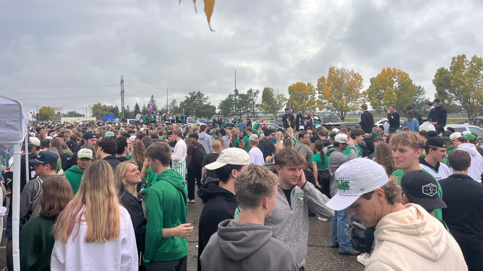 This photo of the UND Tailgate student section. It is very packed with students mingling about in all directions.