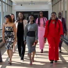Grand Forks Hospitality Featured Image A group of interns catwalk toward the camera with big smiles on dressed to the nines