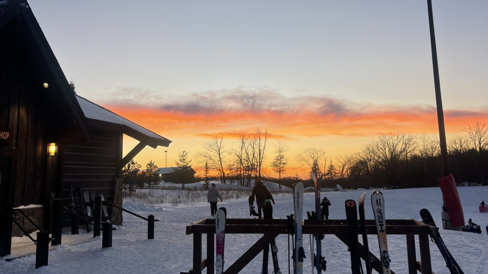 Picture shows part of the Detroit Mountain lodge and ski racks with the sunset in the background on a beautiful January day.