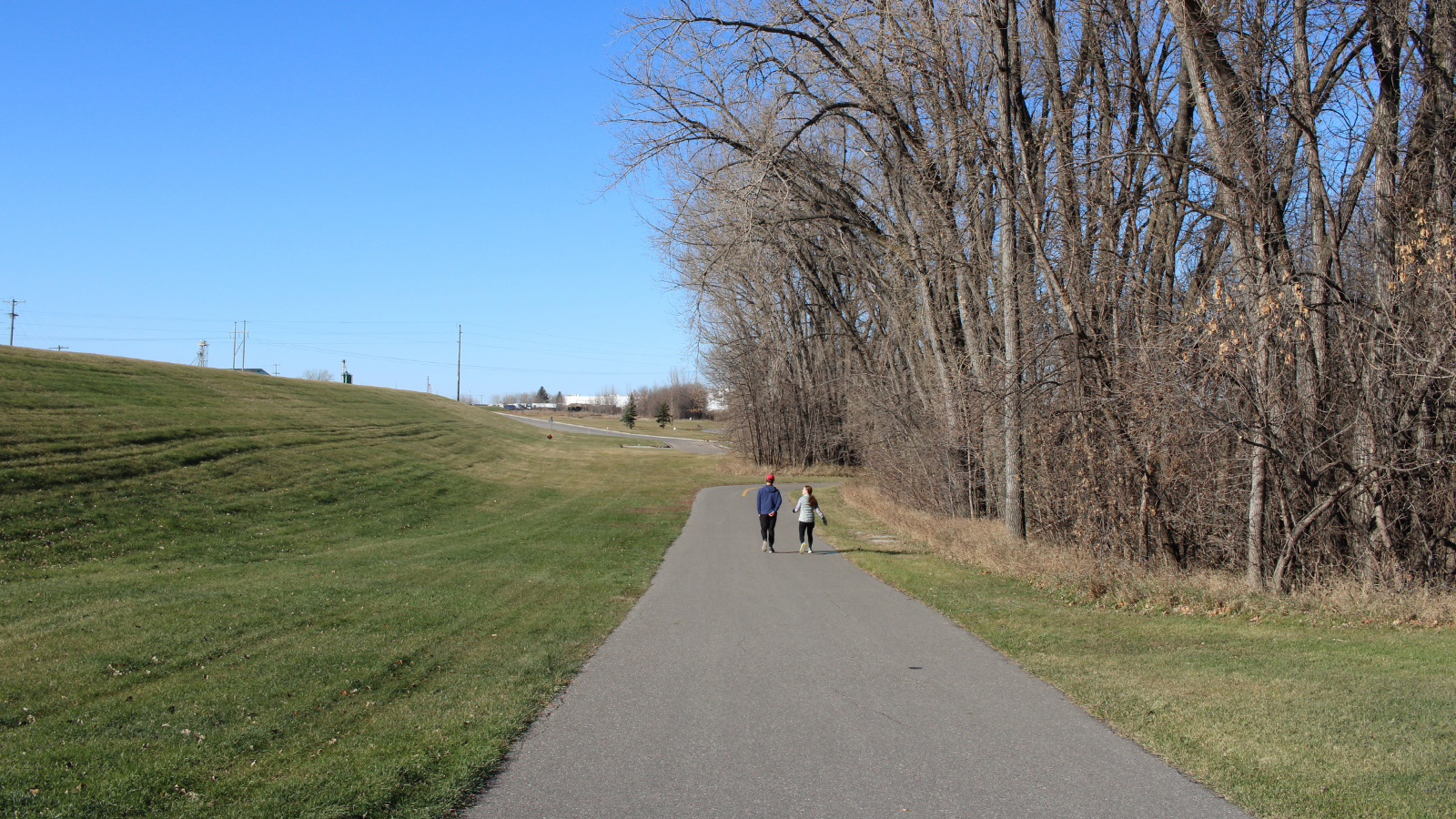 Two kiddos walking in the springtime along the northern part of the bike path/greenway in Grand Forks