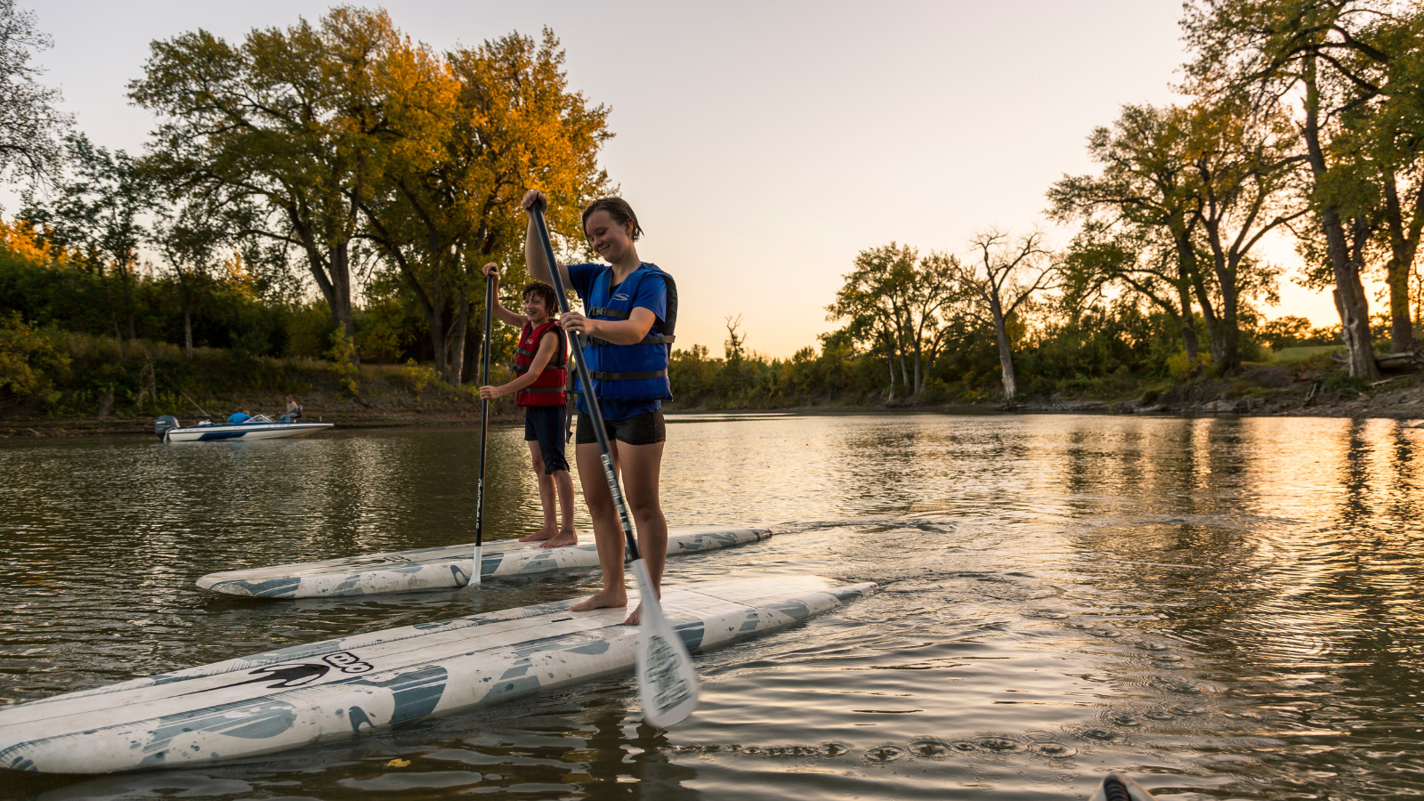 Grand Forks Paddle Boarding Two young Grand Forksians paddle board during golden hour on the Red River