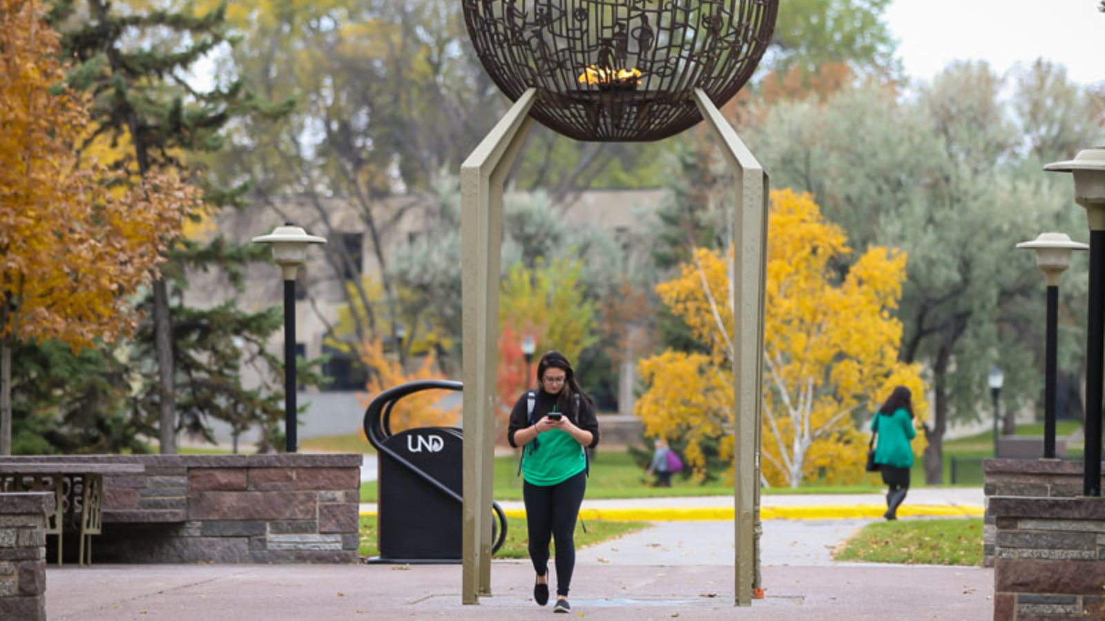 Student on campus UND student walking on campus