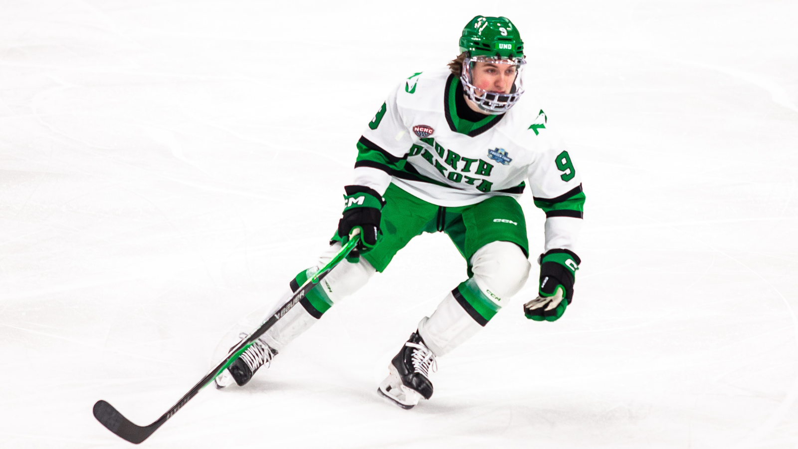 UND Hockey Player UND Men's hockey player skates on the ice in their white uniforms